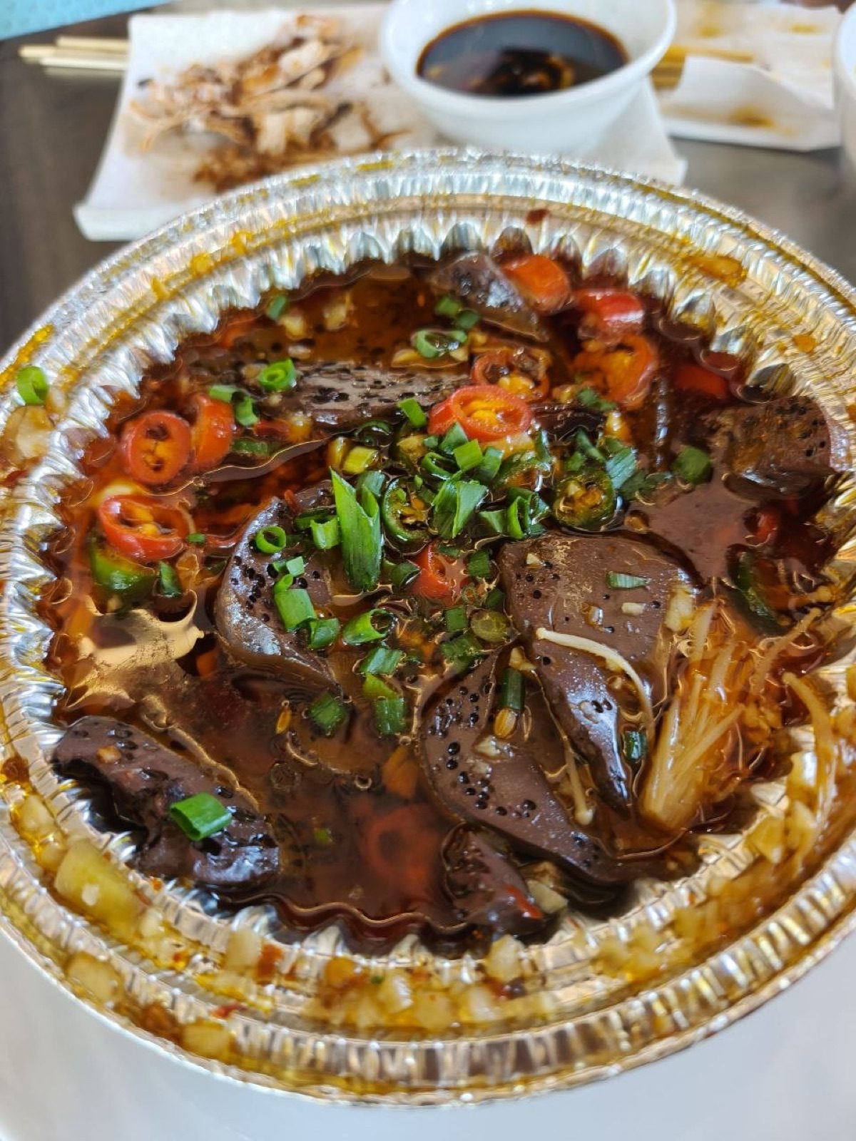 錫紙碗裝盛撒滿青蔥與辣椒的麻辣鴨血